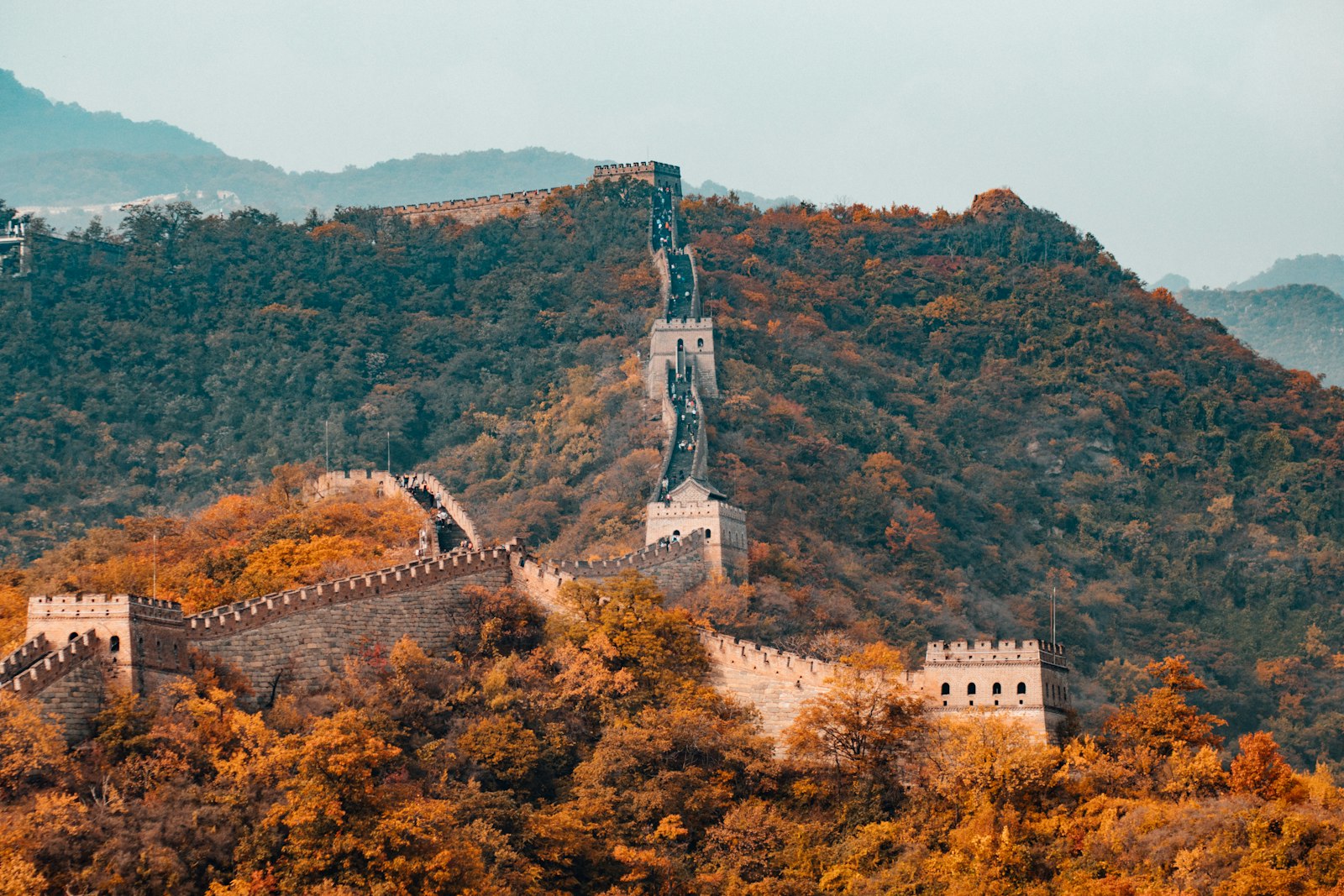 The Great Wall of China winding over misty green mountains